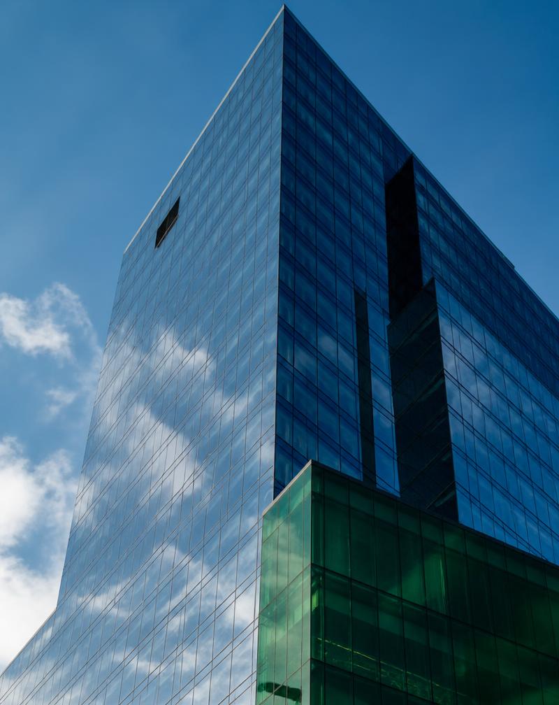 Edificio corporativo moderno de vidrio reflejando el cielo